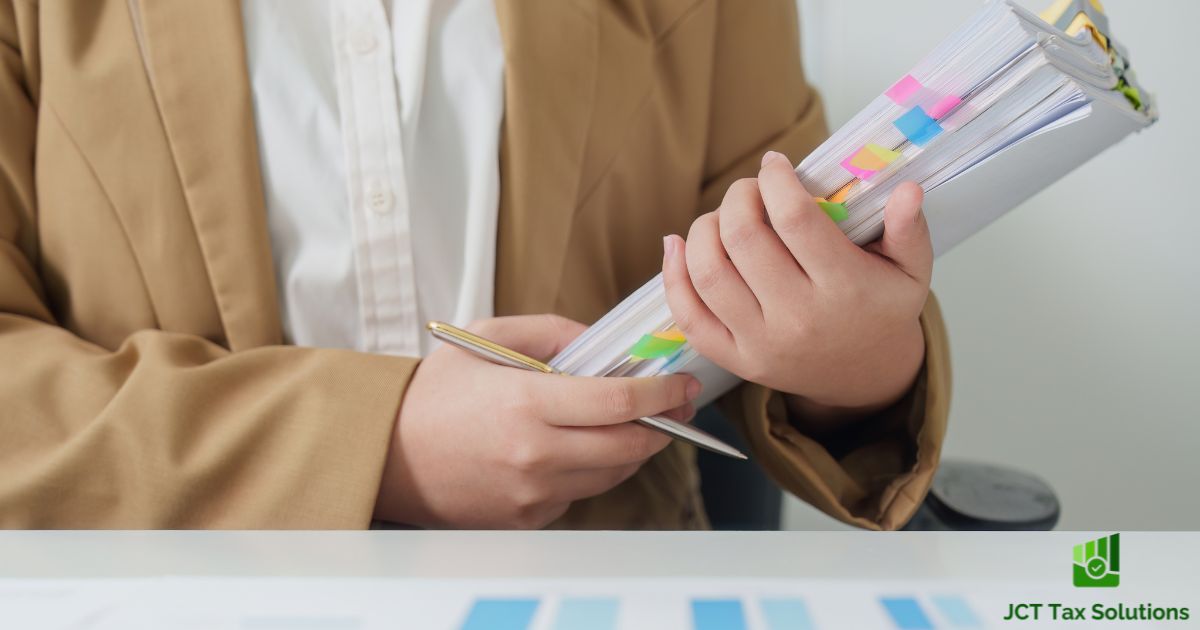 Person holding a stack of documents