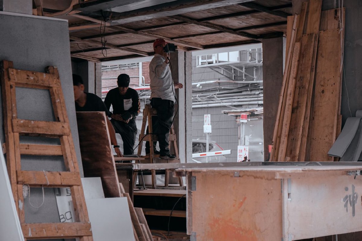 Construction workers collaborating on carpentry inside a building under construction