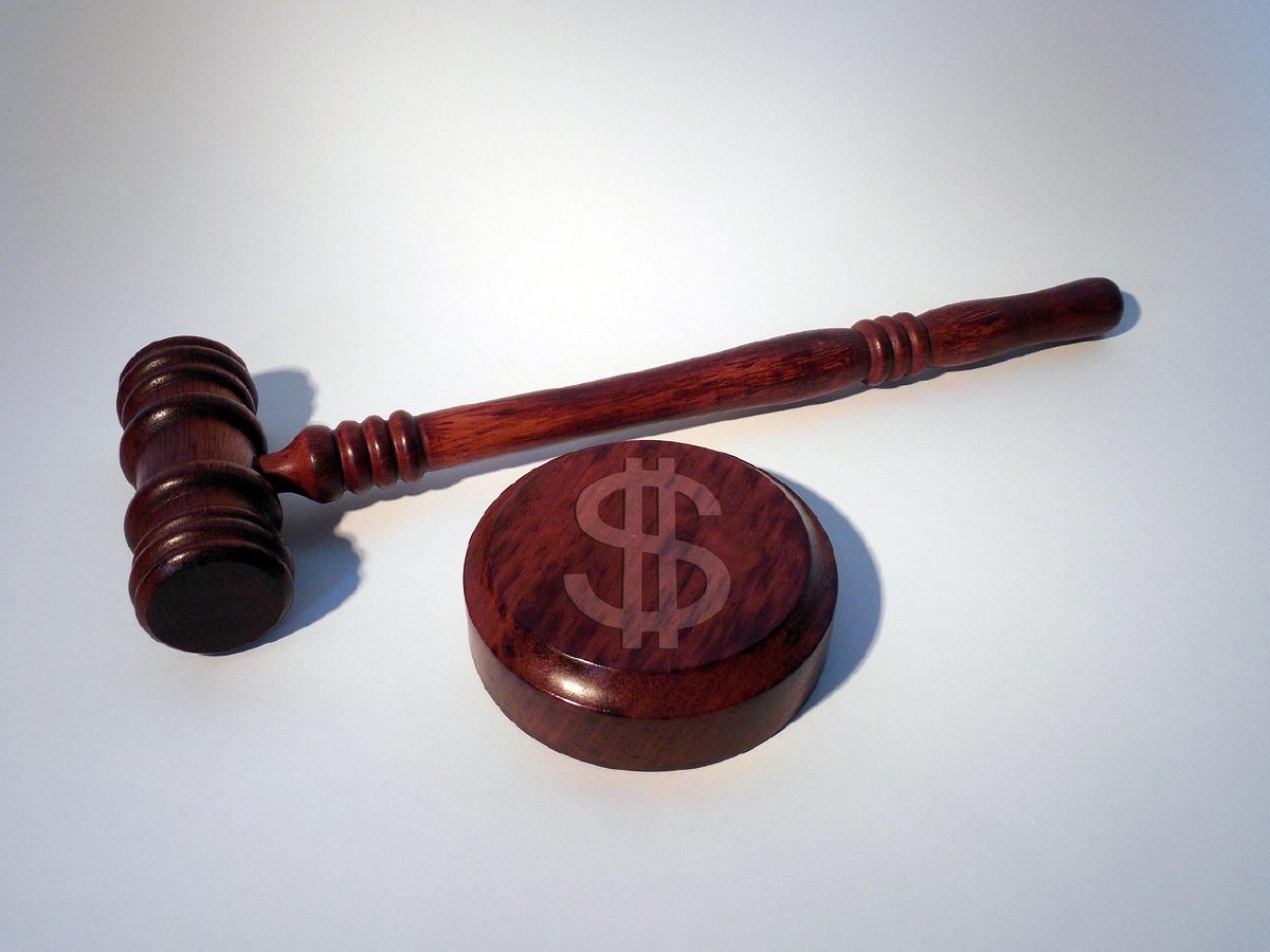 Judge's gavel with a dollar sign on the striking surface, representing a court ruling with financial implications