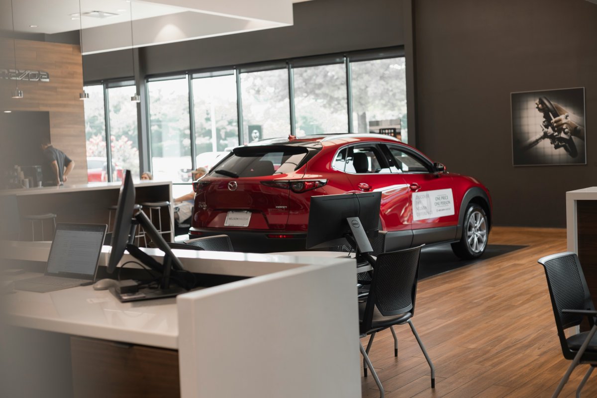 Car inside a dealership with a desk and computers