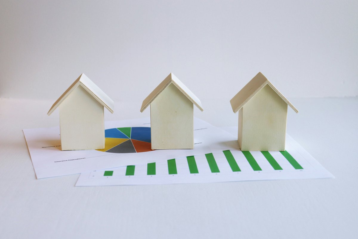 Three small houses sitting on a piece of paper