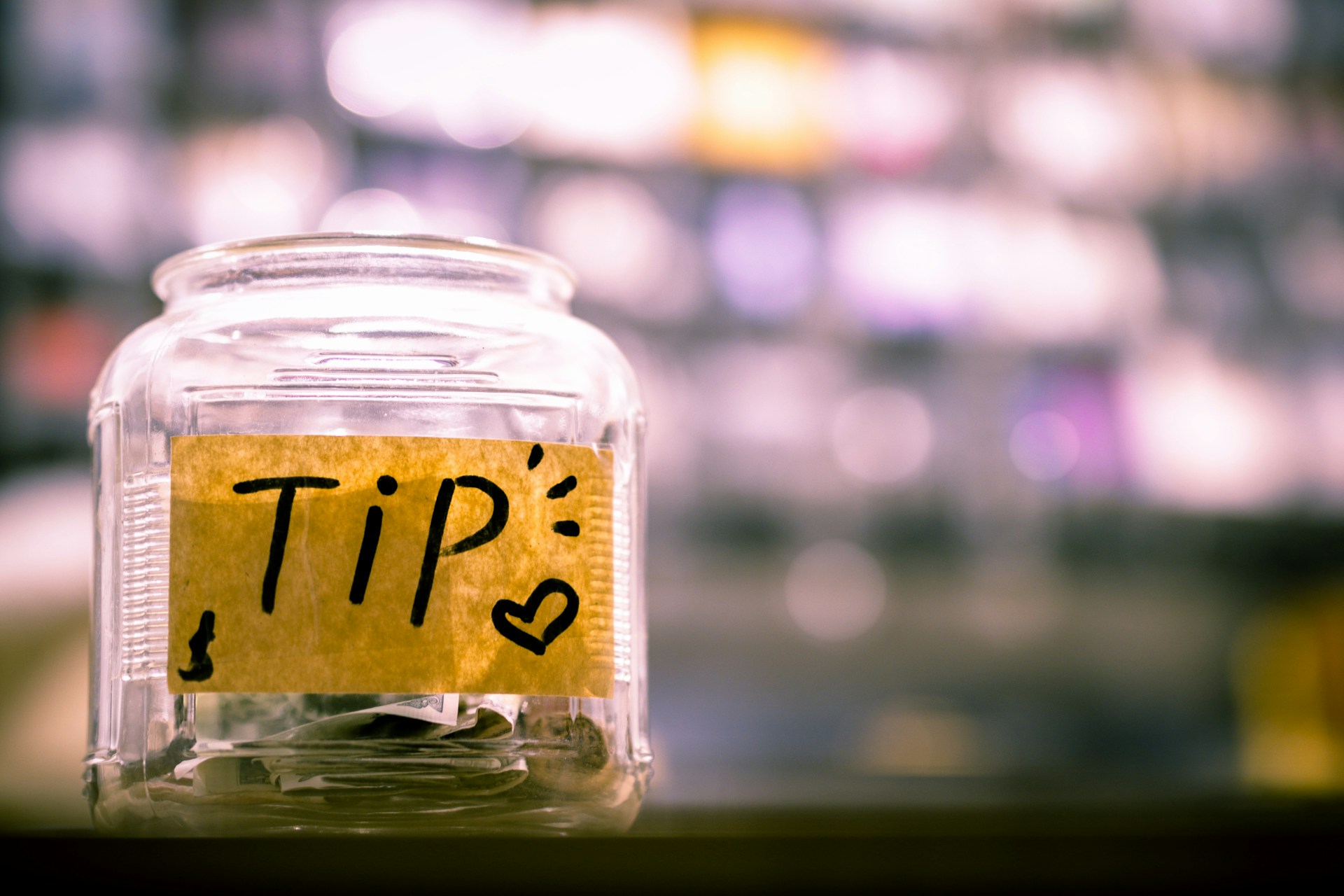 Tip jar with cash, representing the no tax on tips deduction